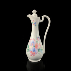 antique crockery for table setting. vintage porcelain decanter with floral pattern on black isolated background