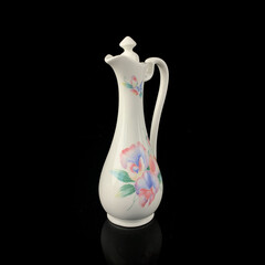 antique crockery for table setting. vintage porcelain decanter with floral pattern on black...