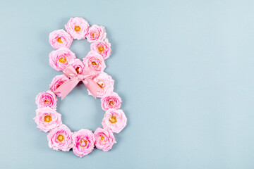 International Women's Day. Banner, flyer, beautiful card for March 8. Pink flowers in the shape of a figure eight on a blue background. Card with pink roses and copy space for text