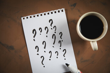 question mark on notepad with coffee cup