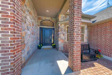 Fototapeta premium Entrance exterior of a house with black door with lockbox, arched transom window, and side panel