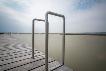 A Wooden Pier with Aluminum Pool Deck Ladder with Hand Rail on Neusiedlersee in Austria.