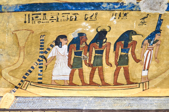 A colorful mural from the tomb Inkherkhau (TT350) on the West Bank of Nile - Thebes, Luxor, Egypt, depicting a boat in the Netherworld with the deceased and four gods: Hu, Khepri, Thoth and Isis
