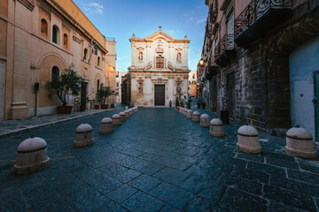 Wide view of the Cathedral of San Cataldo in the old town of Taranto at sunrise with person