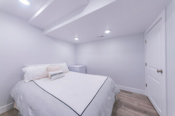 White bedroom interior with wooden flooring and white door