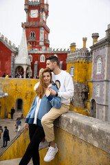 Young beautiful couple walking near National Palace of Pena in Portugal