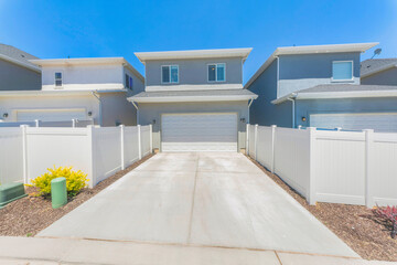Attached garage at the back of a house with white vinyl fence