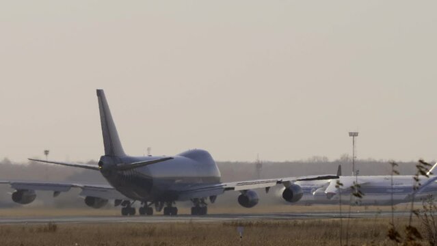 Wide body airfreighter departure. Huge four-engine airliner picks up speed for takeoff