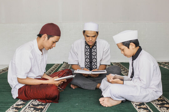 Group of male Muslim teenagers who fill their spare time by taking turns reading the Koran in the mosque