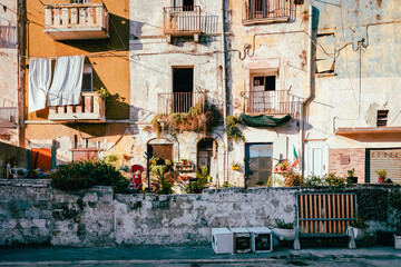 Ruined buildings in the old town of Taranto with household waste on the street