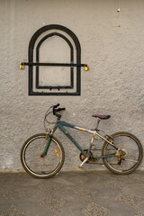 Fototapeta na wymiar Bike parked under a grey metallic window with black frame