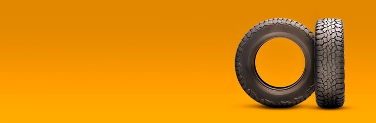 new all-season at tires on an orange background. a long empty copyspace layout - obrazy, fototapety, plakaty