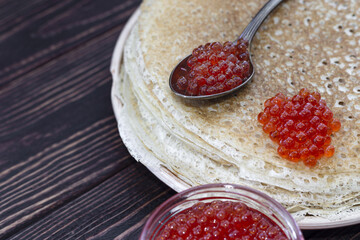 Pancakes on a plate with a jar of red caviar. Maslenitsa holiday, pancakes week. traditional slavic festival meal.