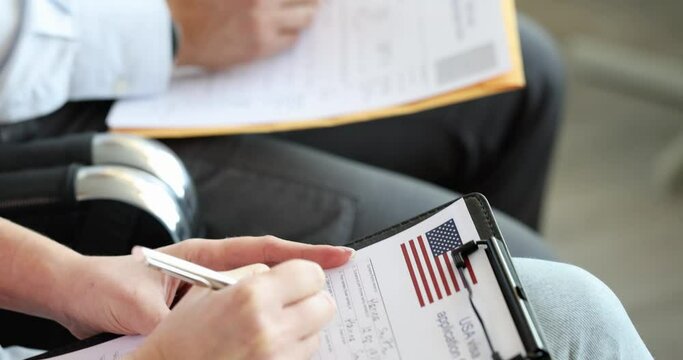 Group of people fill out US visa application form closeup