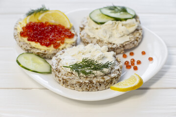 Crispy wheat crackers with red caviar, spread, dill and lemon. Natural Diet Bread