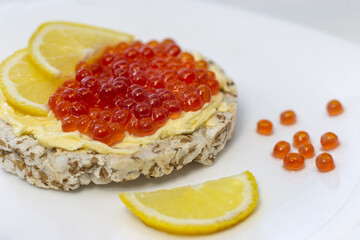 Crispy wheat crackers with red caviar, spread and lemon. Natural Diet Bread
