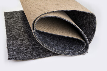 Roll of thin carpet on a white background. Grey polyester texture.