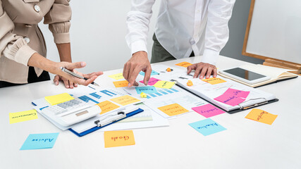 Two business people pointing keyword in post it notes on the table during brainstorming about new business project