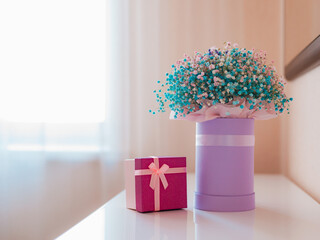 bouquet of beautiful multicolored gypsophila flowers in a gift box on the dressing table on a light background.