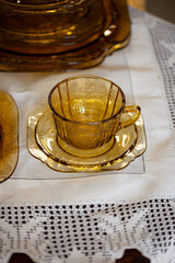 table setting with antique tea glass set with filigree pattern. yellow glass service in the interior. vintage cup close-up