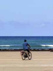 Fototapeta premium Man riding his bike on the beach