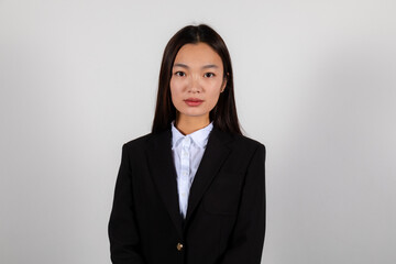 Obraz premium Portrait of a serious young asian business woman wearing a black suite