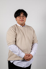 Portrait of a smiling chubby young asian man in glasses on a white background
