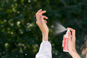 female hands hold a spray bottle. frozen splashes with backlight. High quality photo