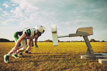 American football players doing tackling drills on a sports field