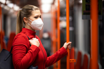 Facial mask concept. A woman wears a mandatory mask inside public transport areas such as a train...