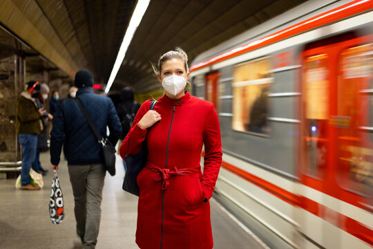 Facial mask concept. A woman wears a mandatory mask inside public transport areas such as a train station, bus and metro. European woman traveler.