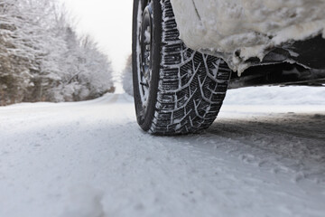 Close up of Winter Tire on Snow and Ice Covered Road