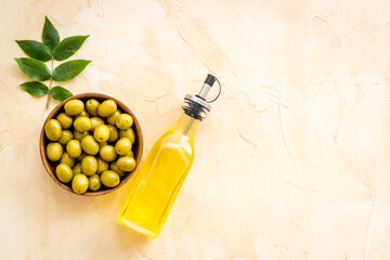 Olive oil in bottle with green olives. Cooking oil background
