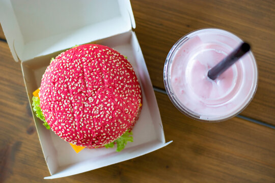 Colored pink beetroot gluten-free hamburger bun with vegetarian burger, with pink milkshake.