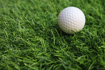 Golf ball close up on green grass on blurred beautiful landscape of golf background.Concept international sport that rely on precision skills for health relaxation..