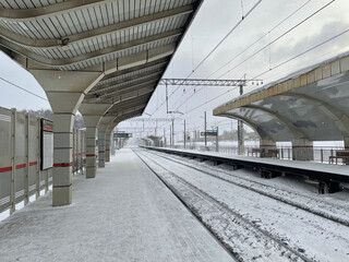 Empty railway platform without passengers in winter at the sunset.