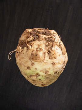 Top view close up of a celeriac root on black rustic background