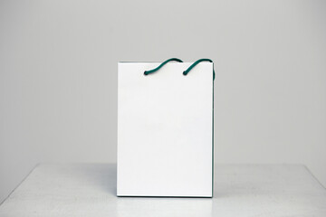 Mockup of blank craft package, mockup of white paper shopping bag with handles on the neutral background