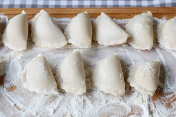 Fototapeta na wymiar A raw homemade dumplings on wooden board.