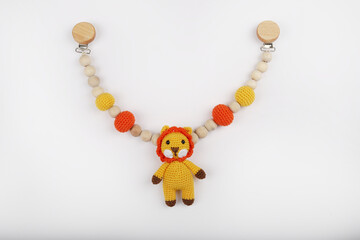 Crocheted lion figure toy for newborns, made with amigurumi art. It stands on a white background.