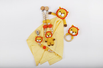 Crocheted lion figure toy for newborns, made with amigurumi art. It stands on a white background.