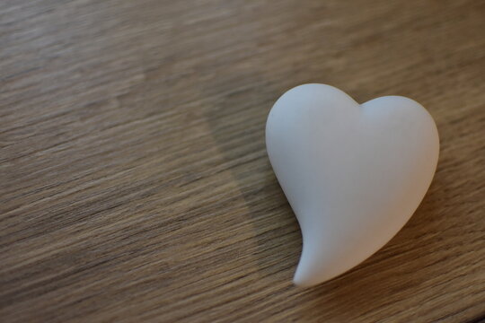Weißes Herz mit Holzhintergrund, Valentinstag