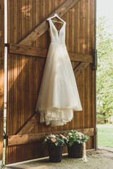 the bride's dress hangs on the barn gate 