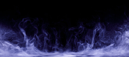 Abstract colored smoke moves on black background. Mystical swirling smoke rolling low across the ground.