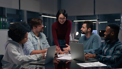 Asian businesswoman leading meeting with diverse employees in office. 