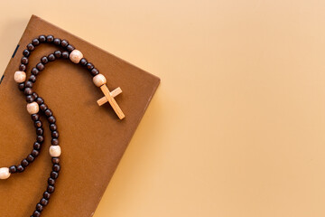 Rosary beads with cross on Bible book. Faith and prayer concept