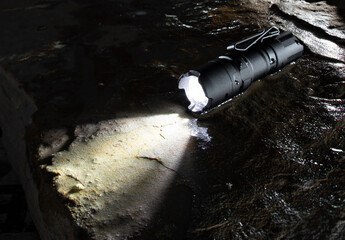 Flashlight on a wet rock