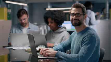 Successful entrepreneur smiling at camera working in modern startup company. 