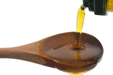Verser de l'huile d'olive dans une cuillère en bois en gros plan sur fond blanc