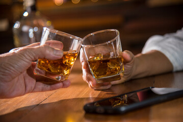 hands hold whisky glass toasting